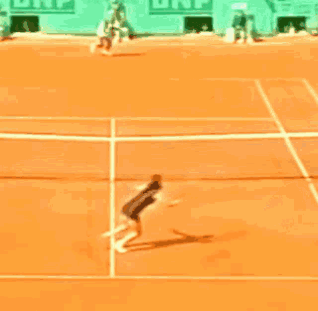 a tennis game is being played on a court with a bnp sign in the background