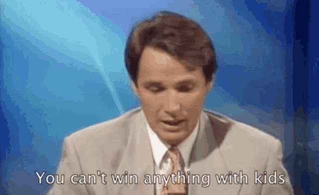 a man in a suit and tie is standing in front of a blue background and says you can 't win anything with kids .