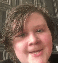 a close up of a person 's face with a blurred background and a smile on their face .