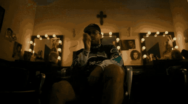 a man sitting in a chair with a cross on the wall