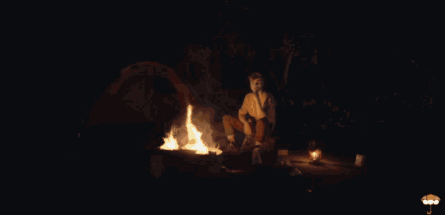 a man in a yellow shirt is holding a piece of fire