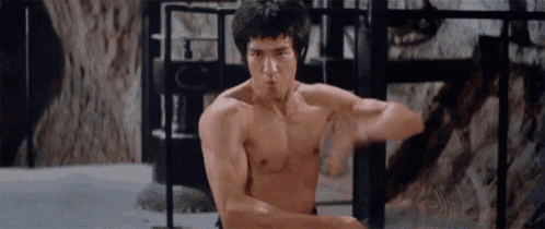 a man without a shirt is flexing his muscles in a cage .