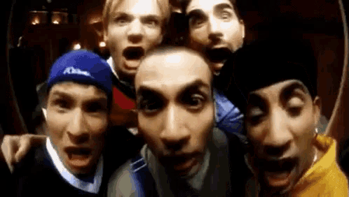 a group of men are making funny faces for the camera .