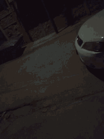 a car is parked on the side of the road in the dark