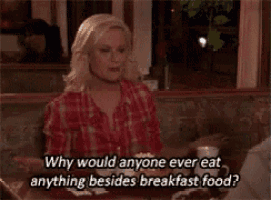 a woman is sitting at a table and talking about breakfast food