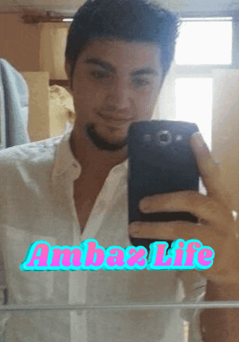 a man taking a selfie in front of a mirror with the word ambaxlife written on it