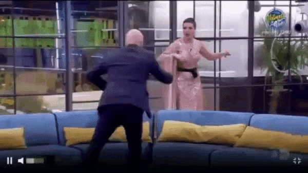 a man in a suit and a woman in a pink dress are dancing in a living room