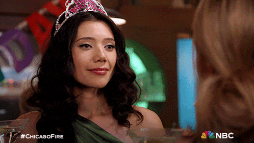 a woman wearing a crown and a green dress with nbc on the bottom