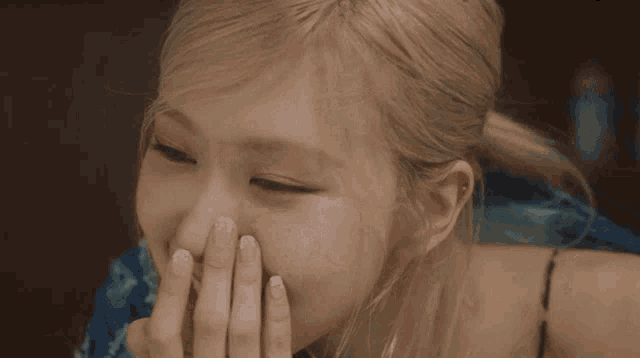 a close up of a woman covering her nose with her hands