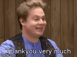 a man is standing in front of a wooden wall and saying thank you very much .