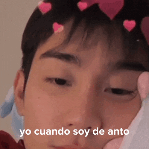 a close up of a person 's face with hearts on it and the words yo cuando soy de anto written on it .