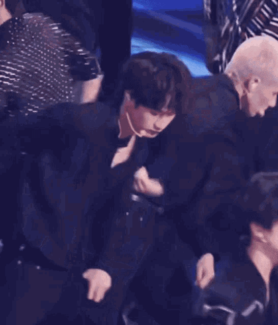 a man in a black shirt is standing next to another man in a black shirt on a stage .