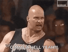 a bald man in a black tank top is standing in front of a crowd and yelling .
