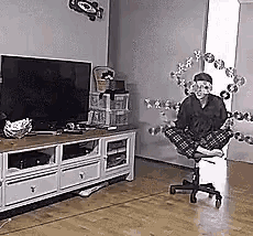 a man is sitting in a chair in front of a christmas tree .