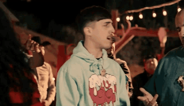 a man wearing a blue hoodie with a cartoon face on it