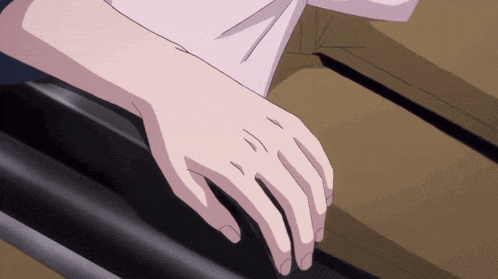 a close up of a person 's hand with a black object in the background