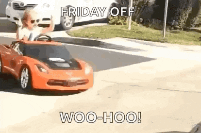 a little boy is driving a toy car down the street .