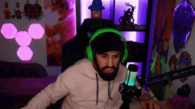 a man with a beard wearing green headphones and a hat