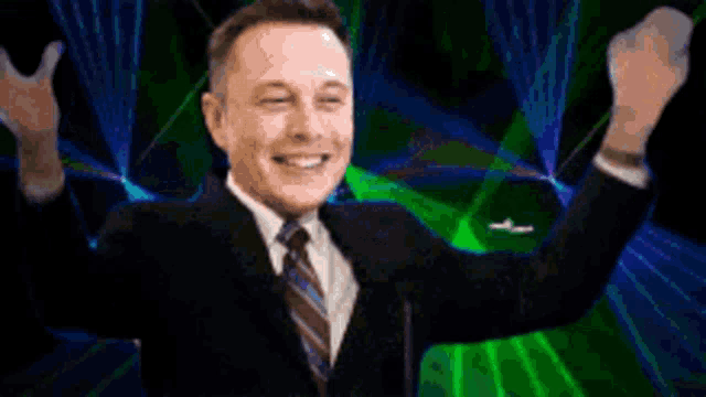 a man in a suit and tie says it 's happening while raising his arms in the air