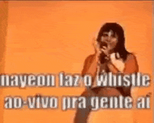 a woman is singing into a microphone with a whistle in her hand .