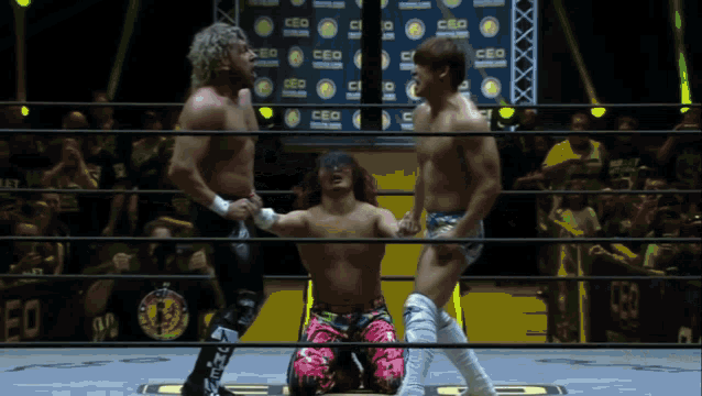 three wrestlers are in a ring with a ceo sign in the background