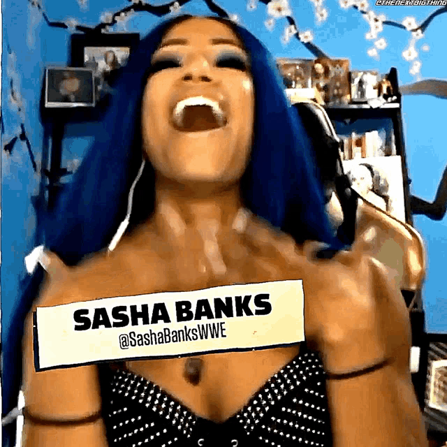 a woman with blue hair and a sign that says sasha banks on it