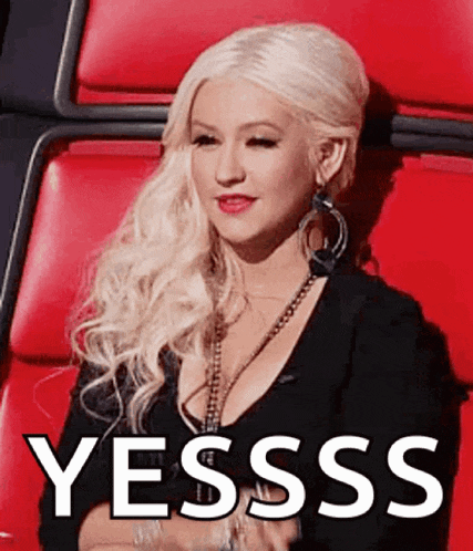a woman with blonde hair is sitting in a red chair with the word yesss written in white