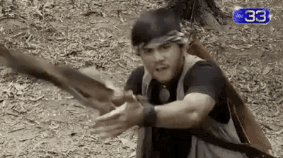 a man with a bow and arrow is holding a sword in his hand .