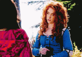 a woman with red hair is wearing a blue shirt