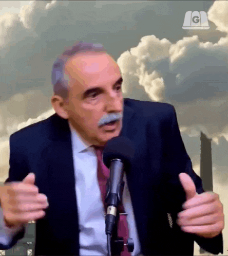 a man in a suit and tie talking into a microphone