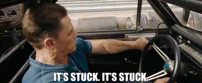 a man is driving a car and saying `` it 's stuck , it 's stuck ''