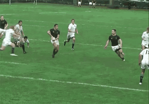 a group of men are playing rugby on a field . one of the players is wearing a number 15 jersey .