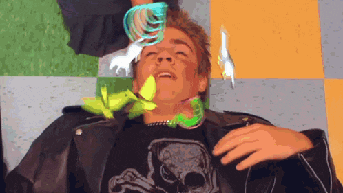 a man wearing a black shirt with a skull on it is laying on the floor