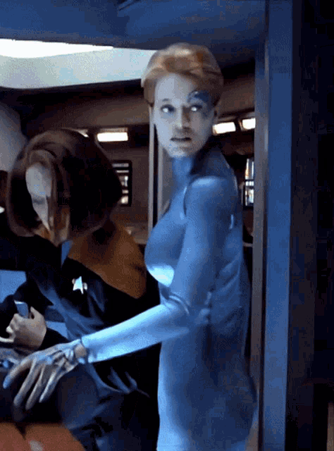 a woman in a blue suit is standing next to another woman in a black shirt