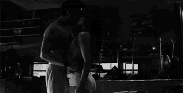 a black and white photo of a man and woman kissing with a caption that says tylko ty