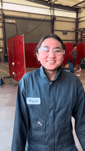 a woman wearing overalls has a name tag that says allyson