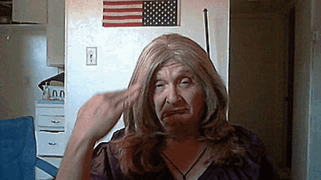 a woman in a wig is making a funny face in front of an american flag ..