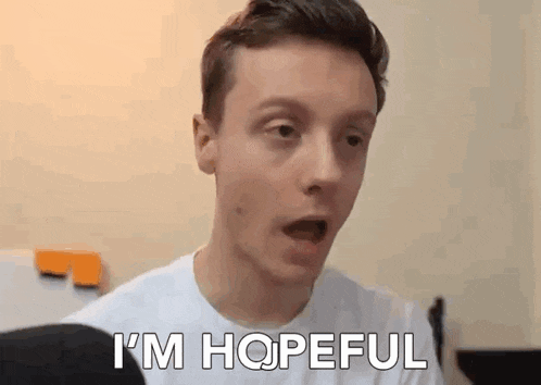 a young man in a white shirt is making a surprised face and saying `` i 'm hopeful '' .