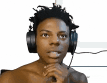 a shirtless man wearing headphones and a microphone looks at the camera