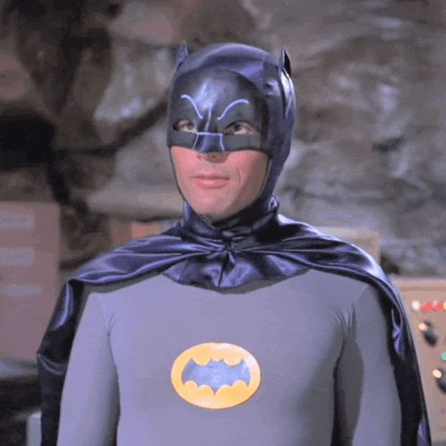 a man in a batman costume with a yellow bat logo