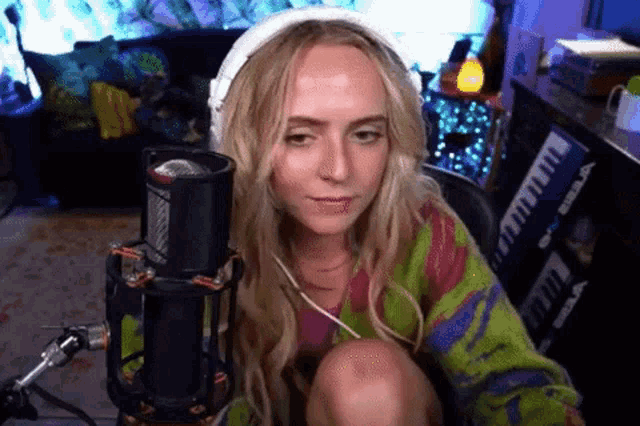 a woman is sitting in front of a microphone while wearing headphones .