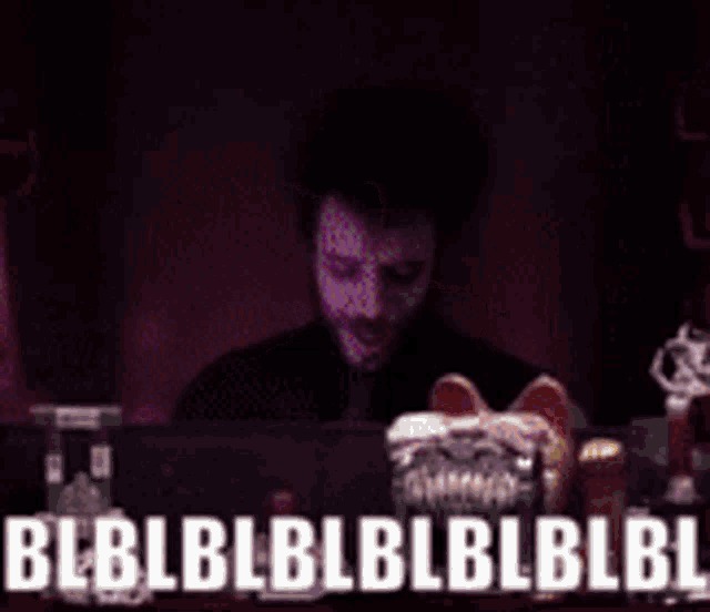 a man sitting at a table with a sign that says ' bbl ' on it