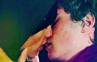 a couple of men are kissing each other on the cheek .
