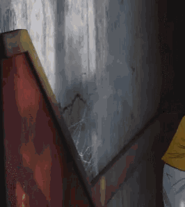 a person in a yellow shirt stands in front of a wall
