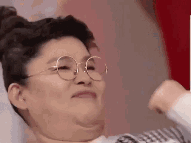 a woman wearing glasses is making a funny face and making a funny face .