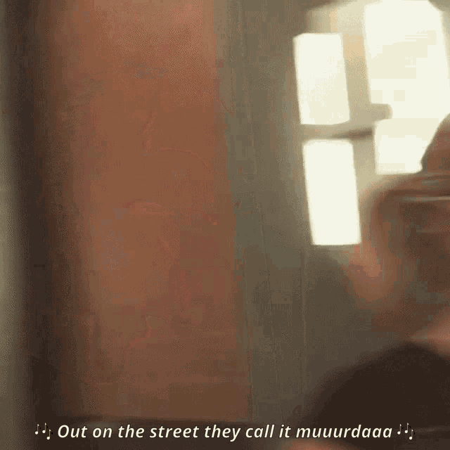 a blurry picture of a person with the words out on the street they call it muuurdaa