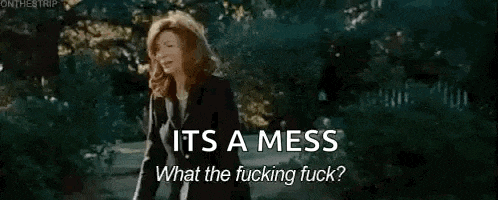a woman in a suit is standing in front of a tree and a hose spraying water .