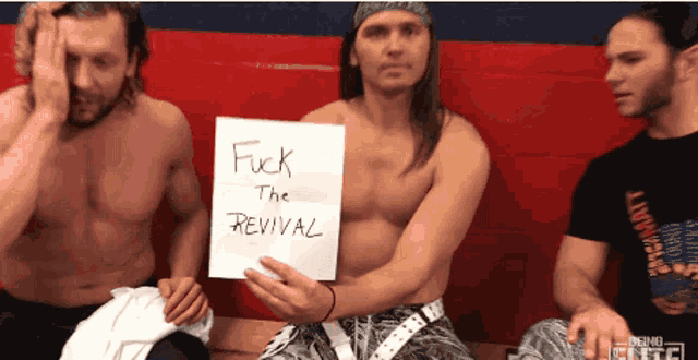 a man holding a piece of paper that says fuck the revival
