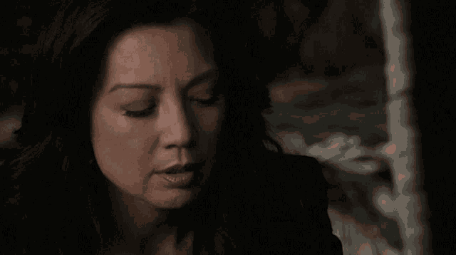 a close up of a woman 's face with a dark background