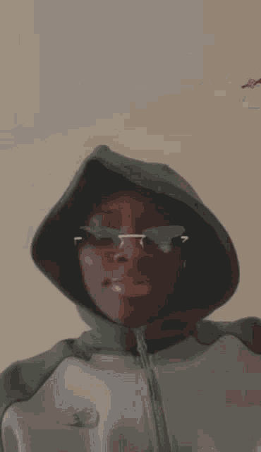 a close up of a man wearing glasses and a hood